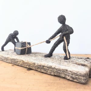 Teamwork - Wire sculptures move a stone together on an old, beautiful wooden board - Handmade Art - Unique