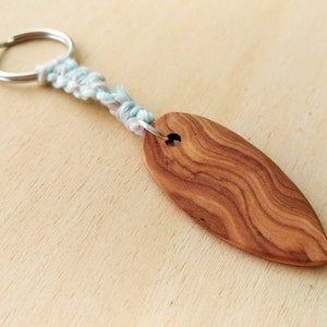small surfboard keychain, lovingly handcrafted from wood, with macrame cord