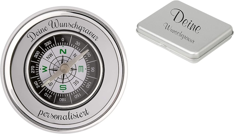 Puede incluir: Una br&uacute;jula plateada con una cara negra y marcas verdes. La br&uacute;jula est&aacute; en una caja de metal plateada con el texto "Deine Wunschgravur" grabado en la parte superior. La br&uacute;jula est&aacute; personalizada.
