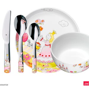 Op de afbeelding: Een kinderservies met een prinsessenthema. De set bevat een vork, mes, twee lepels, een bord en een kom. De roestvrijstalen bestekken hebben roze en oranje accenten. Het bord en de kom zijn wit met prinsessenillustraties.