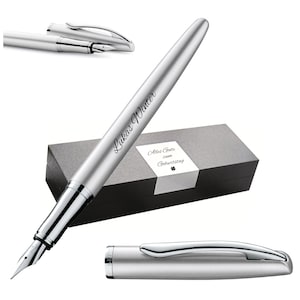 Könnte beinhalten: Ein silberner Füllfederhalter mit dem Namen "Lukas Winter" auf dem Schaft graviert. Der Stift wird mit Kappe und Geschenkbox gezeigt. Die Box hat ein Etikett mit der Aufschrift "Alles Gute zum Geburtstag".