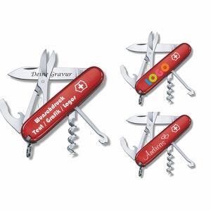 May include: Three red Swiss Army knives with different engravings. The first knife has the text "Deine Gravur" and "Wunschdruck Text / Grafik / Logos". The second knife has the text "logo" in colorful letters. The third knife has the text "Andreas" with two hearts.