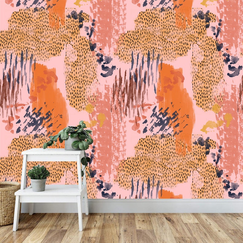 May include: Abstract wallpaper with a pink background and orange, brown, and blue abstract shapes. The wallpaper is shown on a wall with a white shelf and two potted plants.