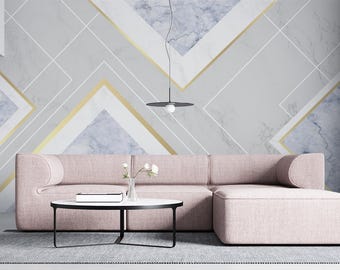 Puede incluir: Salón moderno con un sofá seccional rosa claro, un otomán a juego, una mesa de centro redonda negra y una gran planta en maceta. La pared está decorada con un diseño geométrico de mármol en gris, blanco y dorado. El sofá mide unos 2,5 metros.