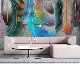 May include: A living room with a large wall mural featuring colorful, stylized feathers in shades of purple, teal, orange, and blue. A light pink sofa and ottoman sit in front of the mural, with a small round table and a potted plant.