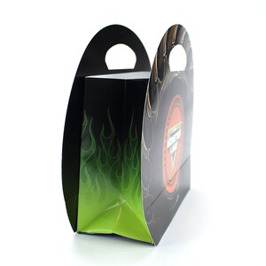 May include: A black and green paper gift bag with a Monster Jam logo and flames. The bag has a handle on the top.