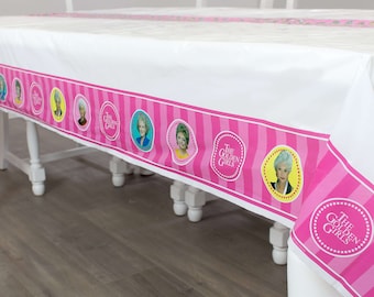 May include: A white plastic tablecloth with a pink and white striped border. The border features images of the four Golden Girls and the text "The Golden Girls".