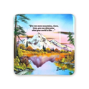 Pode incluir: Um descanso de copo quadrado de vidro com uma pintura de uma cordilheira refletida num lago. O c&eacute;u &eacute; azul claro com nuvens cor-de-rosa. A cita&ccedil;&atilde;o "You can move mountains, rivers, trees, you can determine what your world is like..." est&aacute; impressa na parte superior do descanso de copo. A assinatura do artista "Bob Ross" est&aacute; impressa na parte inferior do descanso de copo.