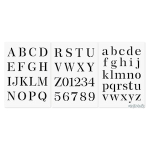 May include: Three white stencils with black uppercase and lowercase letters and numbers. The stencils are arranged side by side, displaying the full alphabet and numbers 0-9.