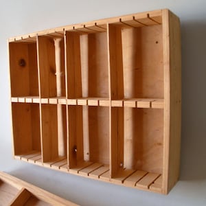 Può includere: Uno scaffale a muro in legno con più scomparti, ideale per organizzare ed esporre piccoli oggetti.