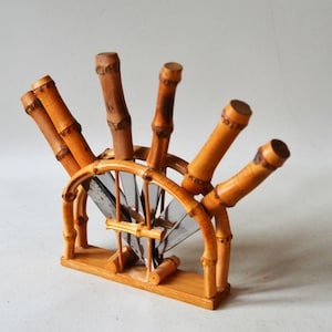 Może przedstawiać: Stojak na noże z bambusa z pięcioma nożami. Stojak wykonany jest z naturalnego bambusa i ma kształt wachlarza.