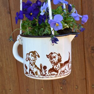 old milk pot as a hanging basket with dog motifs