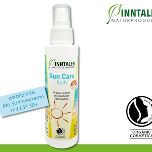 Könnte beinhalten: Eine weiße Flasche Inn taler Sun Care Body Sonnencreme mit einem grünen Etikett und einer Sonnengrafik. Die Flasche ist mit dem Text "Nature & Organic" und "Sun Care Body" beschriftet. Die Flasche ist auch mit dem Text "30+" und "Organic Cosmetics" beschriftet.