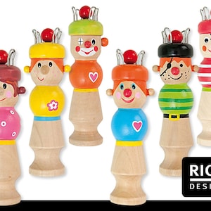 Könnte beinhalten: Eine Sammlung von Holzspielfiguren mit bemalten Gesichtern und farbenfroher Kleidung. Jede Figur hat ein einzigartiges Design, darunter ein Clown und ein Pirat. Die Figuren sind mit einer roten Kugel und Metallakzenten versehen.