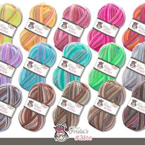 May include: A collection of colorful yarn skeins, each with a label that reads "Frida's #21te." The yarn colors vary, including shades of pink, orange, green, blue, and brown. The skeins are arranged on a white background.