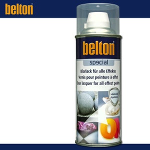 May include: A silver can of Belton special clear lacquer for all effect paints. The can has a blue label with white text that reads "Belton special" and "Klarlack für alle Effekte, Vernis pour peinture à effet, Clear lacquer for all effect paints". The can is surrounded by images of various objects that have been coated with the lacquer, including a stone, a pearl, a gemstone, and a letter.