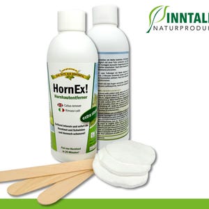 Puede incluir: Dos botellas blancas de removedor de callosidades HornEx! con etiquetas verdes y texto en alemán e inglés. Las botellas están al lado de una pila de discos de algodón blancos y tres palitos de madera.