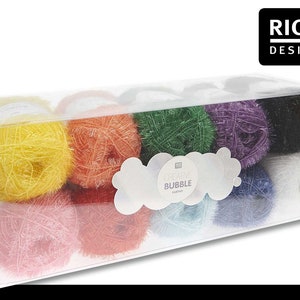 Könnte beinhalten: Ein Set mit 10 bunten Garnknäueln in einer durchsichtigen Plastikbox. Das Garn ist ein flauschiger, strukturierter Typ namens "Creative Bubble" von Rico Design.