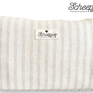 Könnte beinhalten: Eine weiße und beige gestreifte Stoff-Kosmetiktasche mit dem Schriftzug "Scheepjes" in schwarzer Schrift.