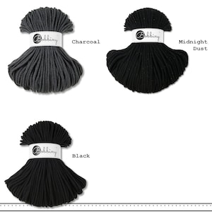 May include: Three skeins of Bobbiny cord in charcoal, midnight dust, and black. Each skein is secured with a white paper band featuring the Bobbiny logo. The charcoal cord is dark gray, while the midnight dust and black cords are solid black.