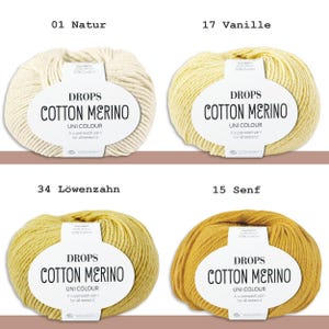 May include: Four skeins of Drops Cotton Merino yarn in various colors. The colors include Natur, Vanille, L&ouml;wenzahn, and Senf. Each skein has a label with the Drops Cotton Merino logo and product information. The yarn is a superwash yarn suitable for all seasons.