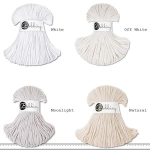 K&ouml;nnte beinhalten: Vier B&uuml;ndel Bobbiny-Baumwollkordel in einer Rasteranordnung. Jedes B&uuml;ndel ist mit einer wei&szlig;en Papierbanderole mit dem Bobbiny-Logo versehen. Die Farben sind als White, Off White, Moonlight und Natural beschriftet und zeigen T&ouml;ne in Reinwei&szlig;, Creme, Hellgrau und Beige.