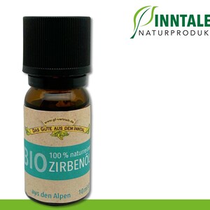 Puede incluir: Una botella de 10 ml de aceite esencial de Bio Zirbenöl 100% natural de los Alpes. La botella es de vidrio marrón con una tapa negra y una etiqueta verde con texto blanco. La etiqueta dice "Das Gute aus dem Inntal" y "Sinntaler Naturprodukte GmbH".