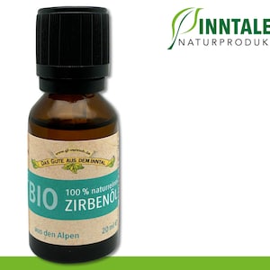 Peut inclure: Une bouteille de 20 ml d'huile de Zirbenol Bio 100% naturelle, fabriquée dans les Alpes. La bouteille est en verre brun avec un bouchon noir et une étiquette verte avec du texte blanc. L'étiquette indique "Das Gute aus dem Inntal" et "100% naturreines Zirbenol".