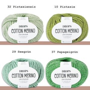 May include: Four skeins of Drops Cotton Merino yarn in various shades of green. Each skein has a white label with the text "DROPS COTTON MERINO" and "UNI COLOUR". The colors are Pistazieneis, Pistazie, Seegr&uuml;n, and Papageigr&uuml;n.