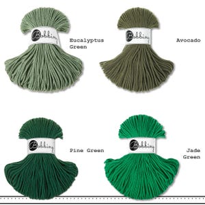 K&ouml;nnte beinhalten: Vier Str&auml;nge Bobbiny-Kordel in einer Gitteranordnung, jeweils mit einer wei&szlig;en Papierbanderole mit dem Text Bobbiny versehen. Die Farben sind als Eucalyptus Green, Avocado, Pine Green und Jade Green beschriftet und zeigen verschiedene Gr&uuml;nt&ouml;ne.