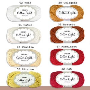 May include: A collection of yarn balls in various colors, including white, yellow, orange, red, and beige. Each ball has a label that reads "DROPS Cotton Light UNI COLOUR" and a number indicating the color.
