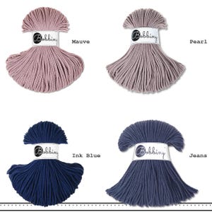 K&ouml;nnte beinhalten: Vier Str&auml;nge Bobbiny-Kordel in einer Rasteranordnung, jeweils mit einer wei&szlig;en Papierbanderole mit dem Text Bobbiny. Die Farben sind als Mauve, Pearl, Ink Blue und Jeans beschriftet und zeigen verschiedene Nuancen von Violett, Grau und Blau.