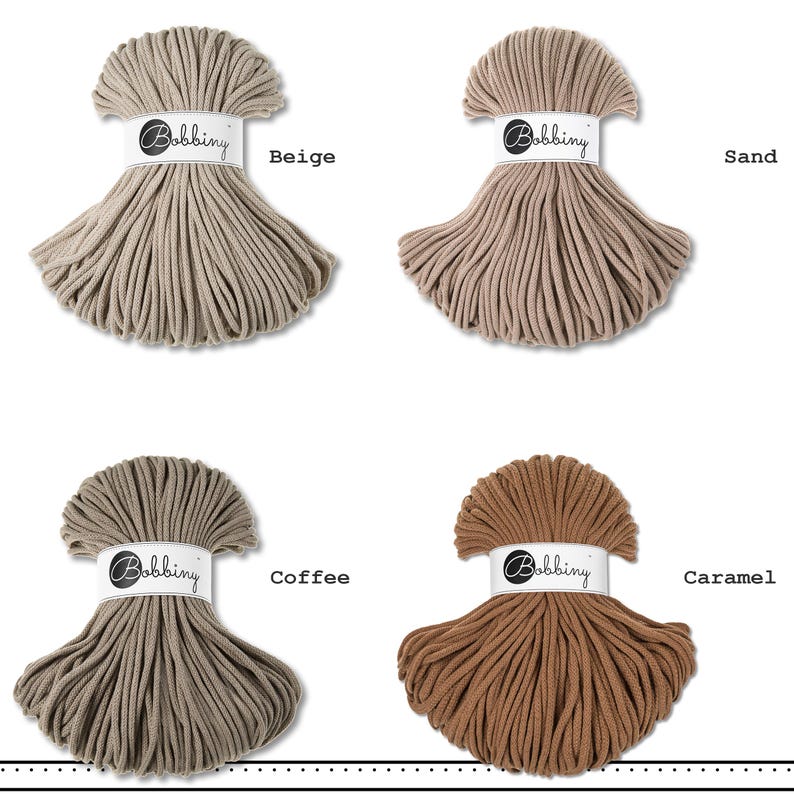 May include: Four skeins of Bobbiny cord arranged in a grid, each featuring a white paper band with the brand name. The colors displayed are beige, sand, coffee, and caramel, showcasing a variety of neutral brown and tan textile cord shades.