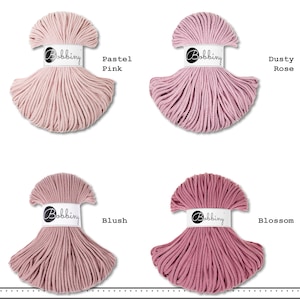 K&ouml;nnte beinhalten: Vier Str&auml;nge aus Bobbiny-Baumwollkordel, angeordnet in einem Raster. Jeder Strang hat ein wei&szlig;es Papieretikett mit dem Markennamen Bobbiny. Die Farben sind als Pastel Pink, Dusty Rose, Blush und Blossom beschriftet und zeigen Rosat&ouml;ne.
