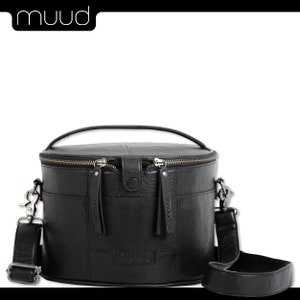 May include: Black leather cylindrical handbag with a top handle and a long adjustable shoulder strap. The bag has two zipper closures and the brand name "muud" is embossed on the front.