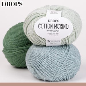 May include: Three balls of DROPS Cotton Merino yarn in shades of green and blue. The center ball has a label that reads "Cotton Merino Uni Colour" and "A superwash yarn for all seasons."