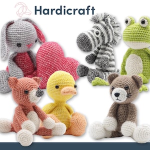 May include: A collection of crocheted stuffed animals including a grey bunny, a zebra, a green frog, a fox, a yellow duck, and a brown cat. The animals are all sitting on a white surface.