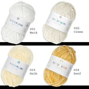 K&ouml;nnte beinhalten: Vier Kn&auml;uel Garn in verschiedenen Farben: Wei&szlig;, Creme, Gelb und Senf. Das Garn hat eine weiche, flauschige, samtige Textur. Jedes Kn&auml;uel hat ein Etikett mit dem Markennamen "RICORUMI" und einem Zahlencode.