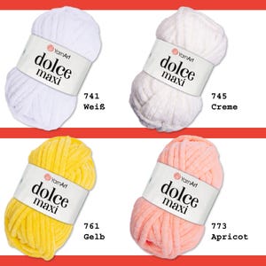 May include: Four balls of yarn in different colors: white, cream, yellow, and peach. Each ball has a label that says "YarnArt dolce maxi" and a number. The numbers are 741, 745, 761, and 773. The colors are labeled as "Wei&szlig;", "Creme", "Gelb", and "Apricot".