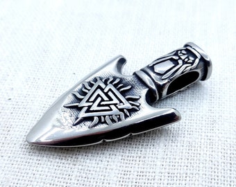 May include: Silver-toned arrowhead pendant with a detailed design of a Celtic knot and a sunburst. The pendant has a hole at the top for attaching a chain or cord.