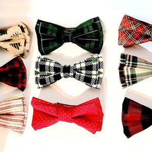 May include: A collection of nine bow ties in various patterns and colors. The bow ties include festive designs with Christmas trees, plaid, polka dots, and stripes. The color palette includes red, green, white, and black.