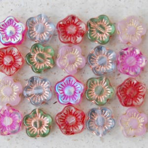Puede incluir: Surtido de 18 cuentas de vidrio con forma de flor iridiscentes en colores rosa, rojo, verde y azul. Las cuentas tienen un centro dorado y son perfectas para la elaboración de joyas.