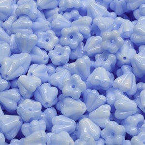 May include: A large pile of light blue glass beads with a flower shape. The beads have a glossy finish and are perfect for jewelry making.