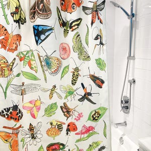 May include: White shower curtain featuring a colorful watercolor illustration of various insects, including butterflies, moths, bees, and beetles. The curtain has a botanical theme with green leaves and floral accents, adding a touch of nature to the bathroom.