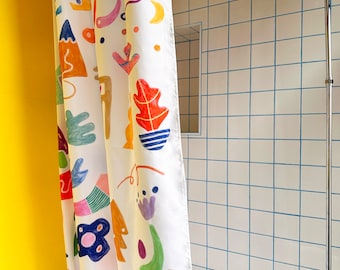 Pode incluir: Um cortina de chuveiro branco com um padrão abstrato colorido que apresenta formas geométricas, flores e outras formas orgânicas. A cortina de chuveiro está pendurada em um banheiro com paredes de azulejos brancos.
