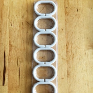 Photo of plastic hooks in a transparent plastic packaging on a wooden background.