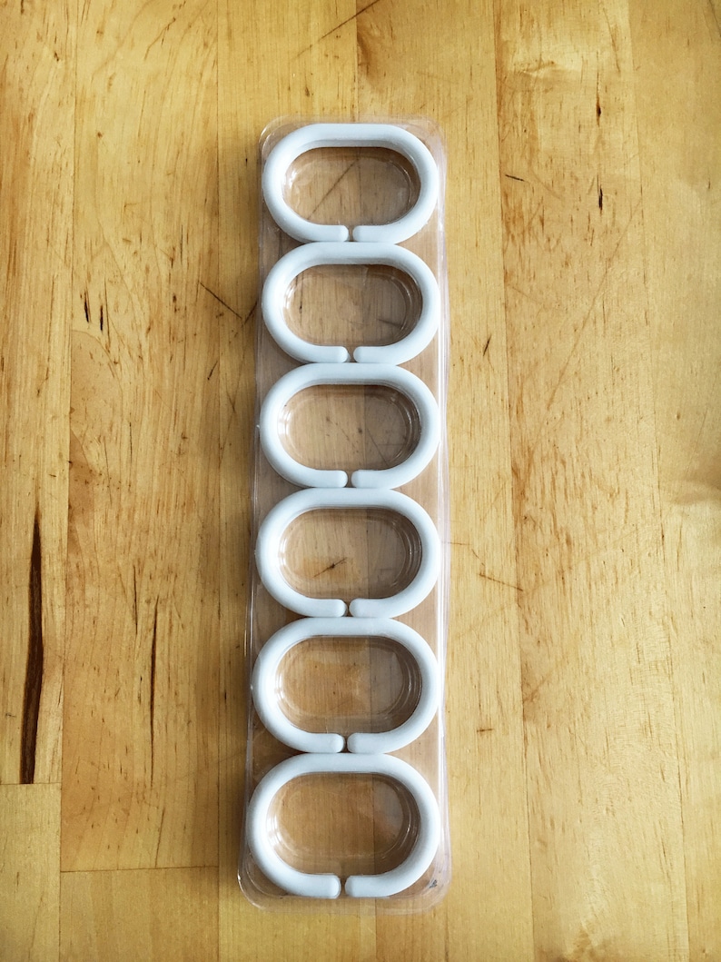 Photo of plastic hooks in a transparent plastic packaging on a wooden background.