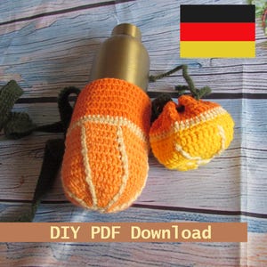 Könnte beinhalten: Ein orange-weiß gehäkelter Wasserflaschenhalter und eine kleine Tasche. Der Flaschenhalter hat einen Riemen und den Text "DIY PDF Download". Die Tasche ist gelb und orange mit einem Kordelzug. Eine Messingfarbene Flasche ist im Inneren.