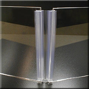 May include: Two clear plastic strips with a grooved design, joined together at the top and bottom. The strips are designed to be used as a divider or separator.