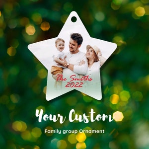 May include: Star-shaped family group ornament featuring a family photo. The photo shows a family of three, with the text "The Smiths 2022" in red. The ornament has a hole at the top for hanging. The words "Your Custom" and "Family group Ornament" are also visible.